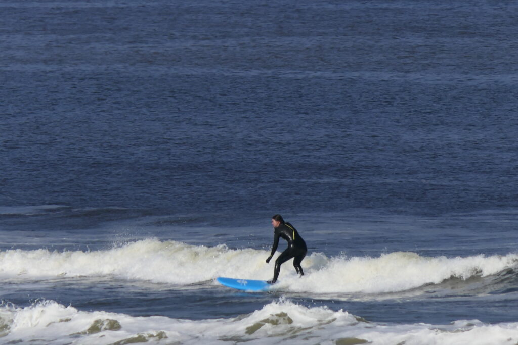 Surfer surft voor het witte schuim uit