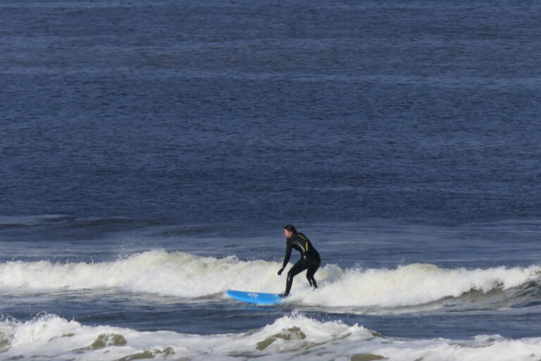 Surfer surft voor het witte schuim uit