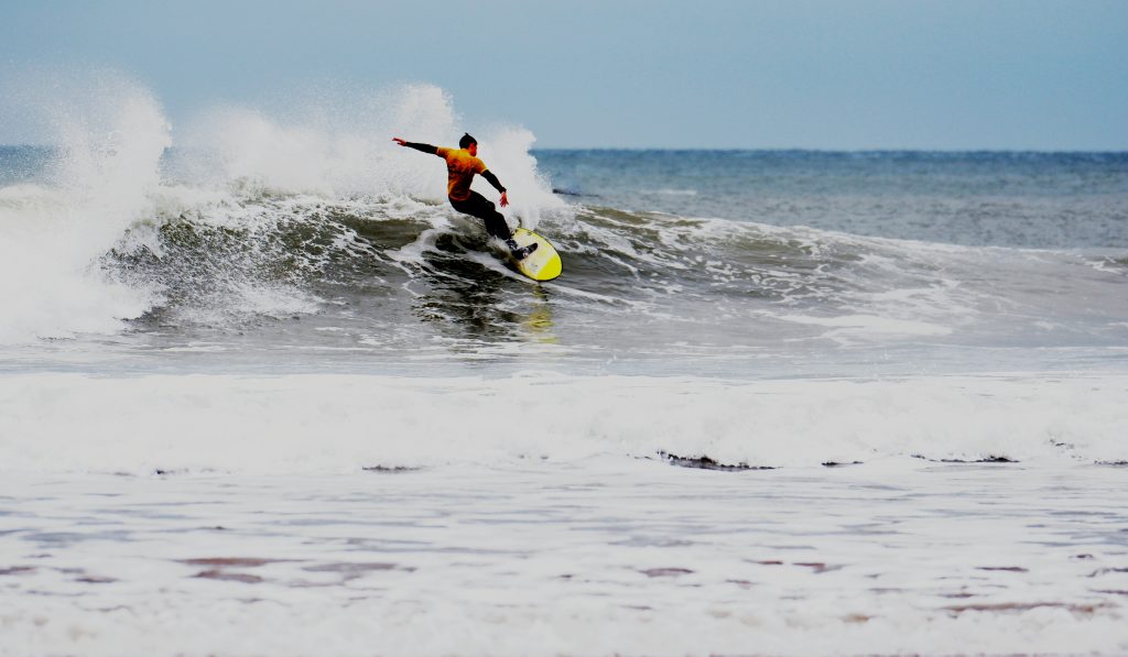 Surfer makes a quick turn with spray